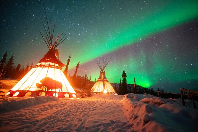 The northern lights glowing green over a snowy landscape